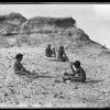 Grace Bugg (left foreground) and Billy Bugg (right foreground) involved in stone tool manufacturing with Uncle Charlie Murray and an unidentified man in background near Tacking Point Port Macquarie.