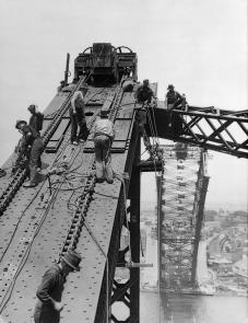 Workmen on incomplete north side of arch.